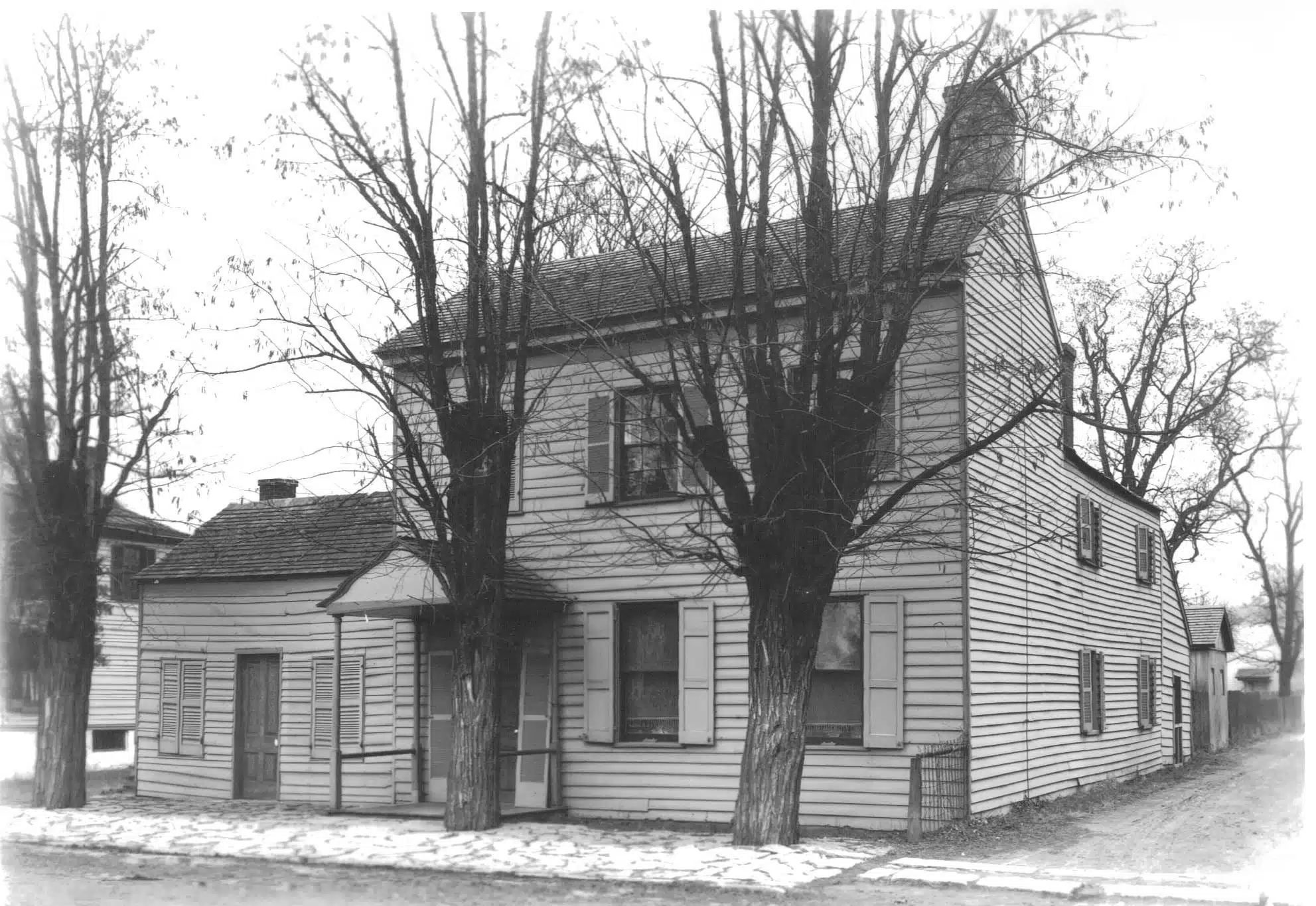 Photo with caption: The Meeks’ house as it looked in 1905 when photographed by J.W. Baker, Ben Winans’ assistant. Notice the stone sidewalk in front and the stone cross walk over the muddy alley crossing. FCPLD collection.