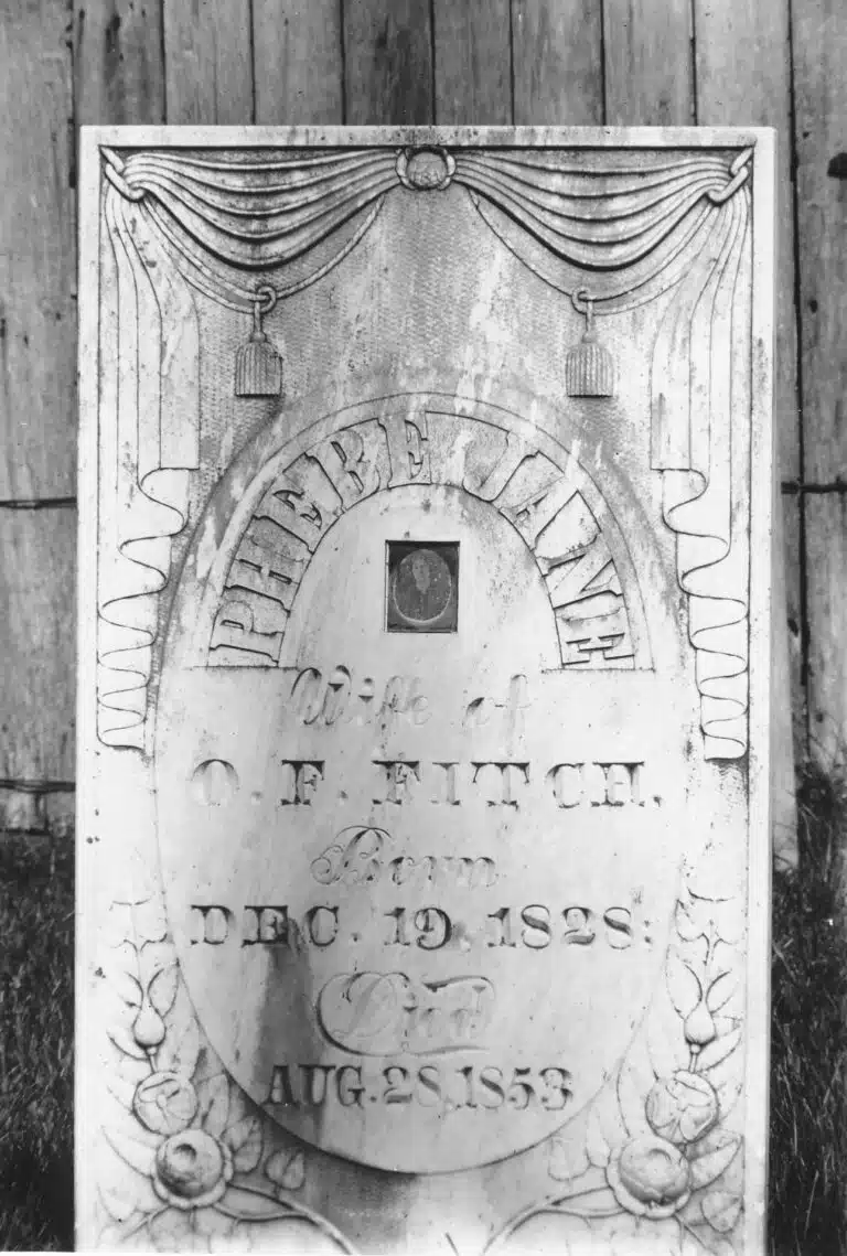 Photo with caption: Phebe Fitch's tombstone as it appeared in a 1907 photograph taken by Ben Winans. Notice the placement of the daguerreotype, centered in the stone, surrounded by her name.