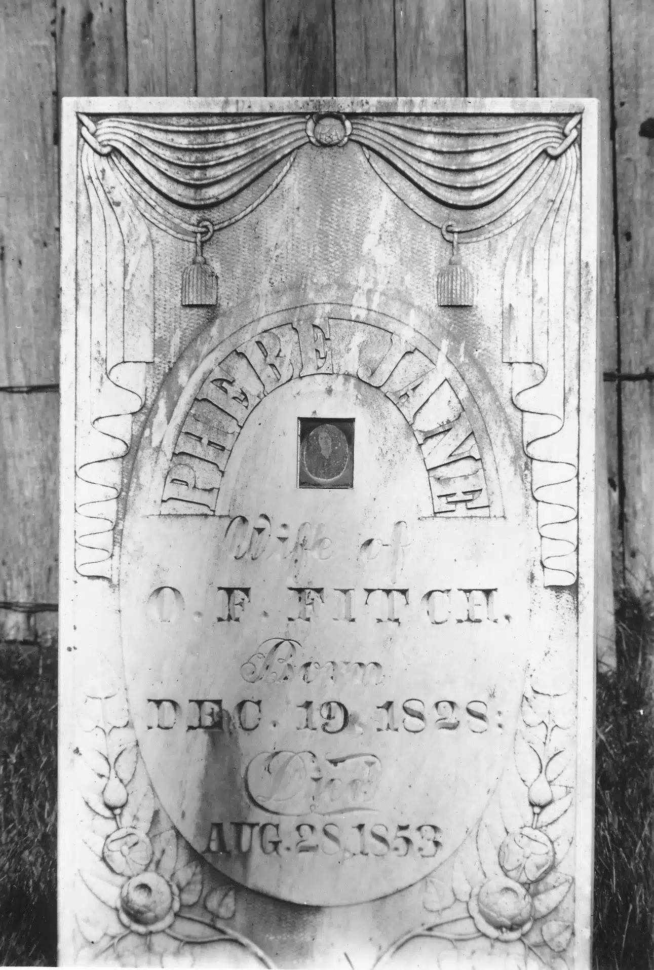 Photo with caption: Phebe Fitch's tombstone as it appeared in a 1907 photograph taken by Ben Winans. Notice the placement of the daguerreotype, centered in the stone, surrounded by her name.